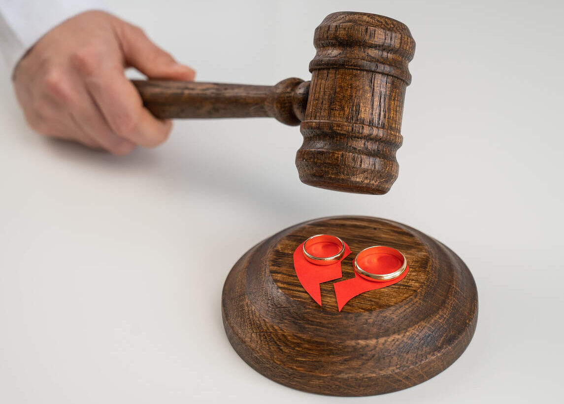 Broken heart and wedding bands on a gavel base, representing a contentious divorce in California and the need for legal strategies.